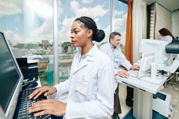 Doctors in ophthalmology clinic working on computers and modern equipment