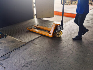 Fototapeta premium Worker driving forklift loading shipment carton boxes goods on wooden pallet at loading dock from container truck to warehouse cargo storage in freight logistics, transportation industrial, delivery