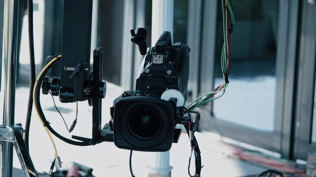 Film crew in outdoor studio shooting video. Camera on crane jib. Filmmaking industry.