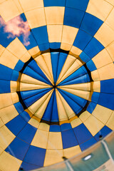 Naklejka premium Close up of inside of colourful blue-yellow hot air balloon. Air balloon, view of the flame inside of a hot air balloon being inflated