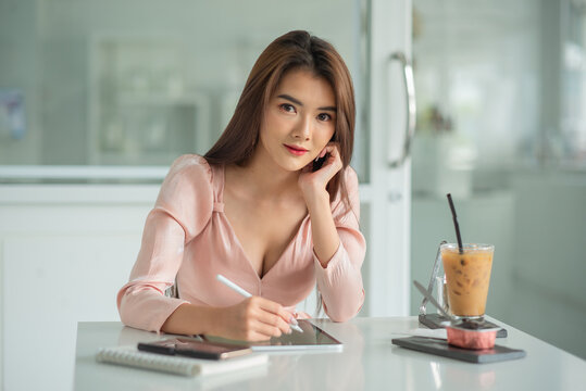 Portrait Of A Female Entrepreneur Looking Into The Camera While Working With Digital Tablet In An Office Room.