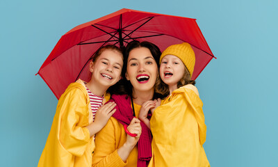 Family with umbrella on colored background.