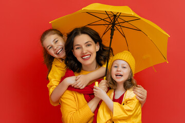 Family with umbrella on colored background.