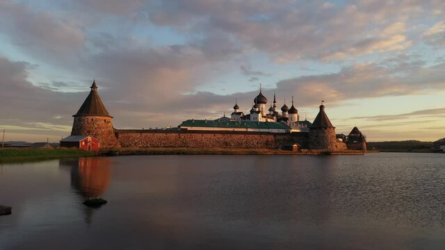 ancient fortress near the lake at dawn filmed from a drone