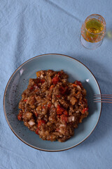 Baked eggplant and peppers salad on a blue plate. Minimalism.