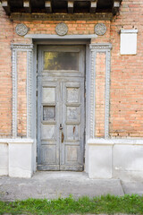 Antique doors of the main entrance to the house, with molding on the facade