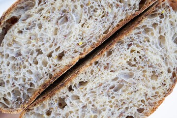 Composition in natural light. Two halves of round homemade yeast-free (whole grain) bread, close-up