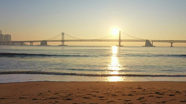 Aerial view, Drone view,Drone footage, beautiful aerial landscape of Busan city South Korea and Busan Gwangandaegyo bridge in the morning and the sun rise,The scene at the beach and the sun