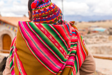 Woman with traditional colourful clothing with her baby , in Chinchero, Peru
