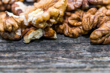 Walnut kernels on aged weathered pine wood board close up macro shot, space for text.
