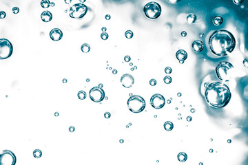 Bubbles of air on the smooth surface of blue water as an abstract background
