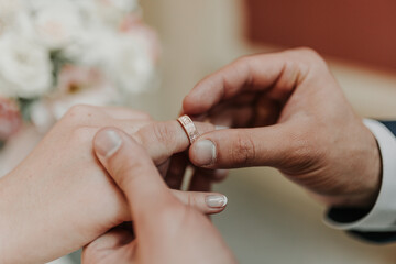 Obraz na płótnie Canvas The bride and groom exchange wedding rings.