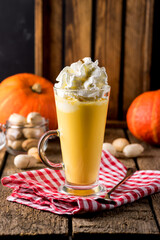 Tasty Autumn Pumpkin Spice Latte with Milk and Cream Ripe Pumpkin Autumn Hot Drink Red Napkin Wooden Background