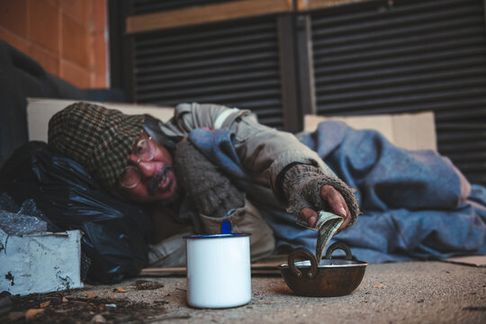 Someone is giving e few dollars to homeless man