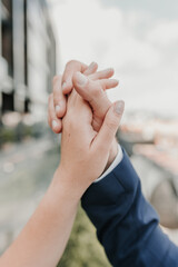 Male and female hands reach out to each other and touch the sky with their fingers.