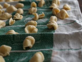 Dinner time at home with the family. On a tablecloth numerous orecchiette, a typical product of southern Italian cuisine.