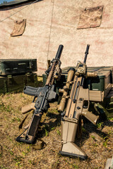 Two automatic rifles leaning on metal suitcase at military base