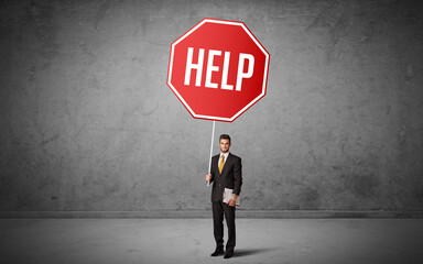 Obraz premium Young business person holding road sign with HELP inscription, new rules concept