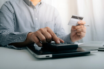 Business people use tablets and hold credit cards as an online shopping concept With a calculator and a book placed on the table