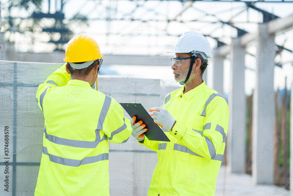 Poster Civil engineer checking work with clipboard in progress of construction project at construction site.