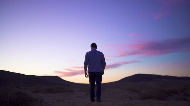 Man walks off into desert dusk, Fuerteventura