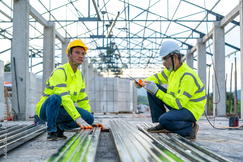 Aufkleber construction engineer team with clipboard checking work with at construction site.