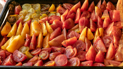 tray with sliced tomatoes, different colors and shapes, autumn harvest