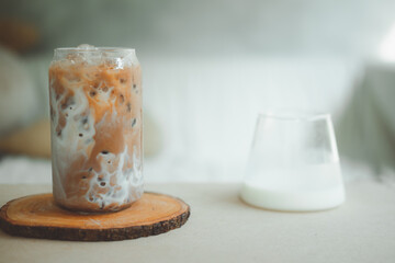 Iced coffee with fresh milk being poured into it showing the refreshing drink