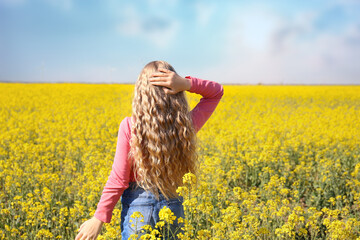 Fototapeta premium Girl with curly long hair on a background of field