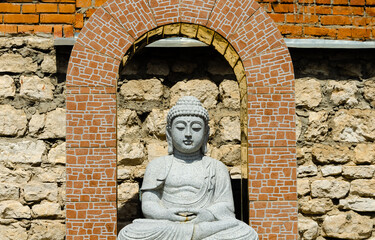 Stone Buddha statue in a brick arch