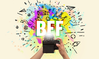 Close-up of a hand holding digital camera with abstract drawing and BFF inscription