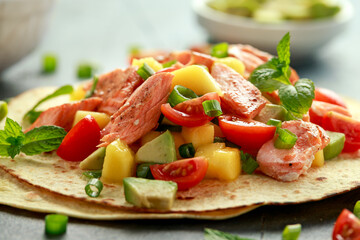 Salmon fish tacos with mango, avocado, tomato, spring onion and lime. Mexican food