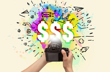 Close-up of a hand holding digital camera with abstract drawing and $$$ inscription