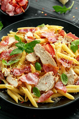 Chicken, bacon Penne pasta with parmesan cheese and basil. healthy food.