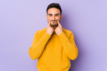 Young caucasian man isolated on purple background doubting between two options.