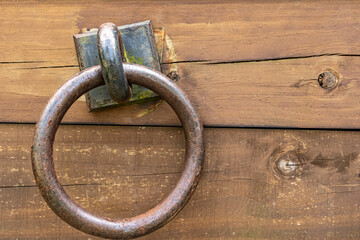 Wooden old cracked shabby plank with rusty door ring