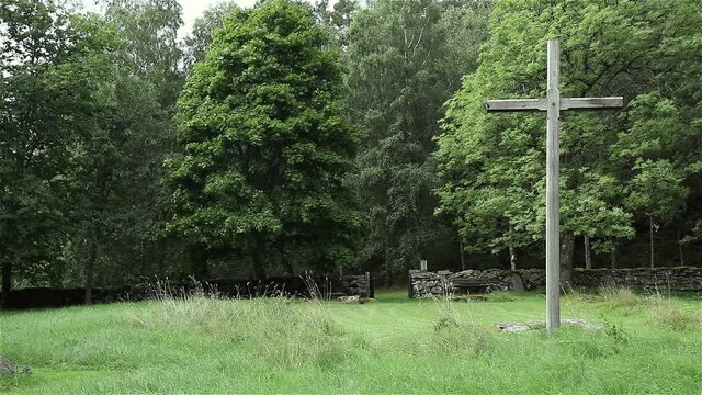 A tall wooden cross dominates this old abandoned church site that has now become a forest cemetary.
It stands in the middle of a field where the old church altar once stood.