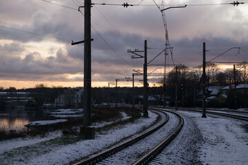 Fototapeta na wymiar Railroad tracks in a winter foggy morning sprinkled with snow.