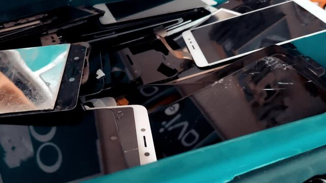 Slow Motion of Heap Of Broken Phone Display Screens Of A Used Smartphones. Mobile Phone. 4K