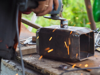 a man handles metal with an angle grinder. sparks from metal.