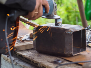 a man handles metal with an angle grinder. sparks from metal.