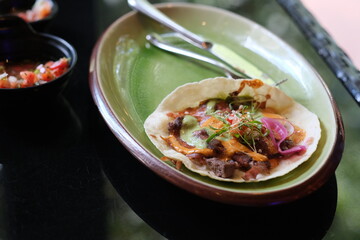 close up taco with in plate on table. Traditional Mexican food. Blur background