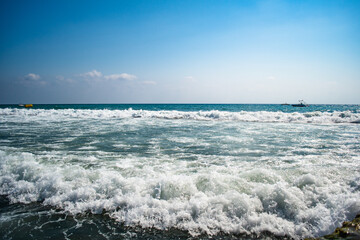 Fototapeta na wymiar Beautiful sea waves splash with white foam on a blue ocean surface background.