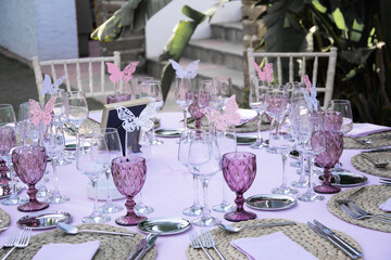 Pink and white decoration of a wedding menu and table with colorful plates and cups