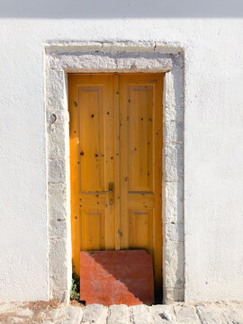 Wooden yellow door at the Village of Vuno, in the south of Albania, Balkans.