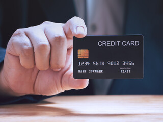 Businessman holding or showing black creadit card for shopping online. E-commerce, commercial, payment concept.