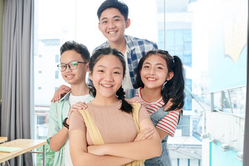 Group of cheerful Vietnamese school children smiling and looking at camera