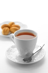 Close up view of dessert plate and cup of tea on white background