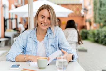 Obraz na płótnie Canvas Beautiful blonde woman with pretty smile working outdoor