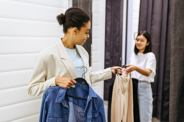 Smiling girls in fitting room, clothing store